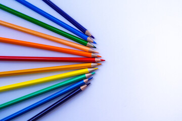 Color pencils lined with an angle on a white background and copy space