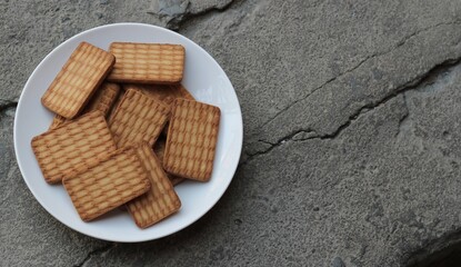 Indian style biscuits/cookies on white plate with concrete floor background
