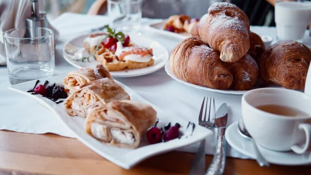 Abundant restaurant food table with delicious pancakes, croissants, pastries. Continental morning breakfast in all inclusive hotel resort.