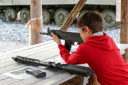 young boy with a machine gun in the outdoor shooting gallery