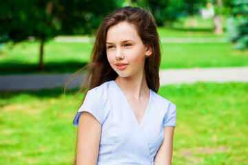 Portrait of a young beautiful brunette  girl in summer park