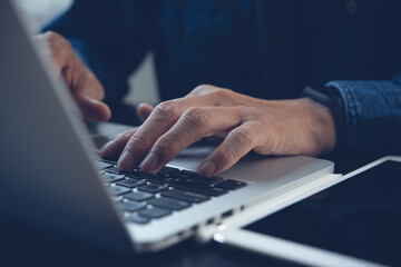 Naklejka na ściany i meble Close up of man hand typing on laptop computer keyboard 