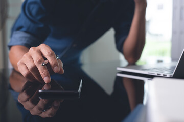 Casual business man surfing the internet on mobile phone online working from home