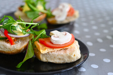 Fresh bread buns sandwiches served with egg omelet and vegetables on a plate