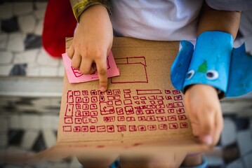 Closeup  horizontal shot of a child playing on a handmade cardboard computer
