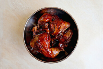 Homemade Kalasan Grilled Chicken (Ayam Bakar) with nickel bowl from up above high angle view, is one of an Indonesian food from Kalasan, Yogyakarta with sweet and savory tastes from black soy sauce