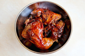 Homemade Kalasan Grilled Chicken (Ayam Bakar) with aluminium bowl from up above high angle view, is one of an Indonesian food from Kalasan, Yogyakarta with sweet and savory tastes from black soy sauce