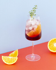 Aperol cocktail on a colors background. Cold drink with ice cubes. Glass of aperol spritz with orange. Summer Italian cocktail. Selective focus