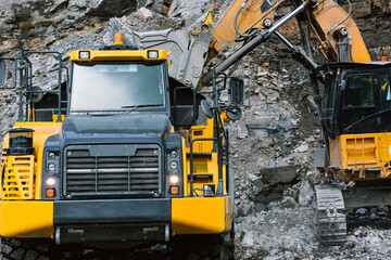 Excavator loads ore into a mining dump truck.