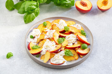 Fresh salad with peaches, Italian Stracciatella cheese, Basil, olive oil and honey. Summer salad, healthy food concept. Selective focus