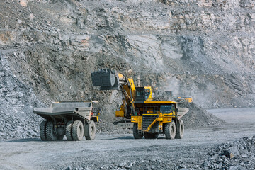 Excavator loads ore into a mining dump truck. © CjVitoS