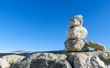 Balance Stones to pyramid in the blue sky background.