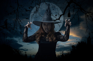 Scary halloween witch standing over cross, church, crow, bat, birds, dead tree, full moon and...