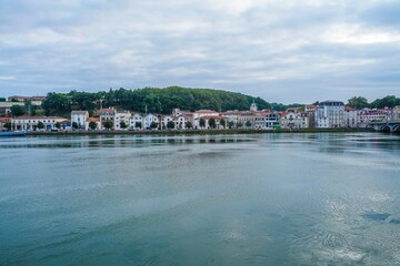 Panoramic shot of the river, buildings, and green nature in Bayonne, France