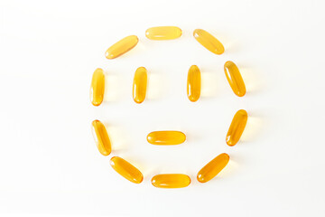 Smiley face from gelatin softgels Capsules of Omega-3 fats on white background. Eicosapentaenoic...