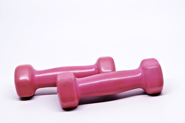 Two pink dumbbells isolated on white background
