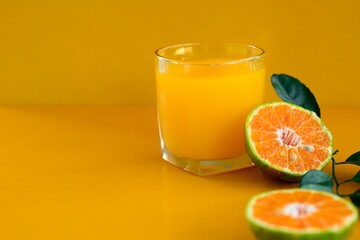 Orange juice isolated on yellow background.