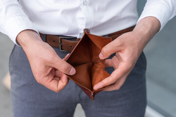 A fired employee due to the crisis opens showing his empty wallet.