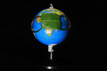 Rejuvenation of earth during Covid19 situation. Concept of Coronavirus in world and COVID-19 pandemic. Globe protected by green leaf. Conceptual photography. Earth globe isolated on a black background