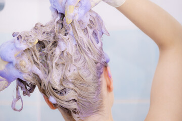 Woman applying toner shampoo on her hair