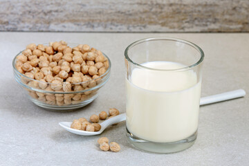 Close up vegan chickpea milk in small drinking glass with beans