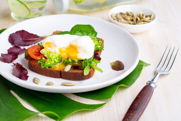 Poached egg on a bruschetta with shallow greens. KETO diet concept