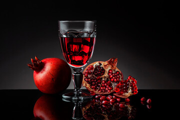 Glass of pomegranate juice with fresh fruits. Pomegranate juice with ice in a wine glass.