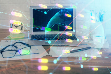 Double exposure of desktop with computer and world map hologram. International data network concept.