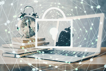 Double exposure of desktop with computer and lock icon hologram. Concept of data safety.