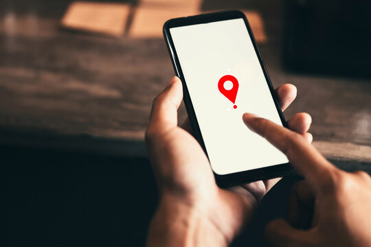 Woman hand using smart phone with navigator location point at coffee shop background. Technology interenet and business travel concept.