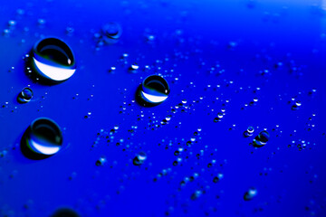 large and small water drops on a blue neon background.trendy classic blue. macro mode.