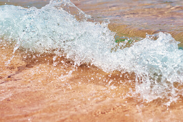 Fototapeta na wymiar Sea wave on the sand beach, soft focus. Summer background