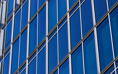 Repeating pattern of blue Windows in close-up.Facade of a modern office building.Exterior of a skyscraper.Urban architecture.Daylight illumination.The view from the bottom up.