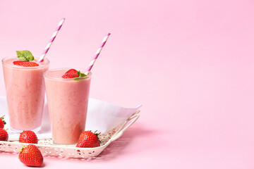 Glasses of tasty strawberry smoothie on color background