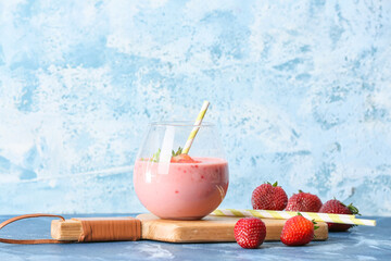 Glass of tasty strawberry smoothie on color background