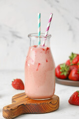 Bottle of tasty strawberry smoothie on white background