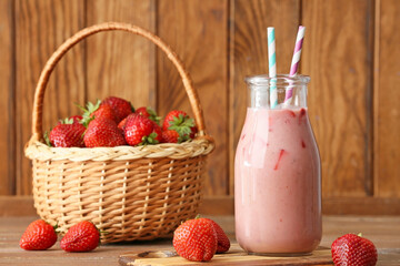 Bottle of tasty strawberry smoothie on table