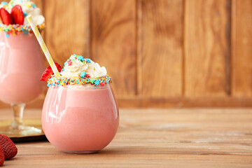 Glass of tasty strawberry milkshake on table