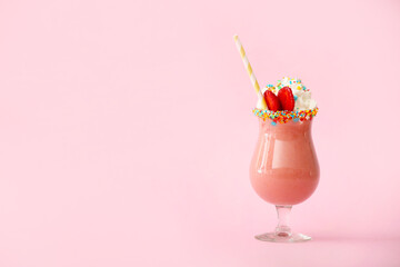 Glass of tasty strawberry milkshake on color background