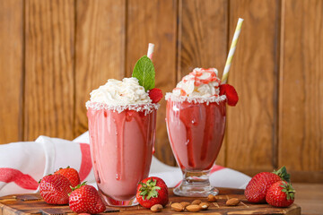 Glasses of tasty strawberry milkshake on table