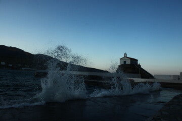 Waves at the small harbour in front of the Chapel of Panagia Thalassini at Andros, Greece 