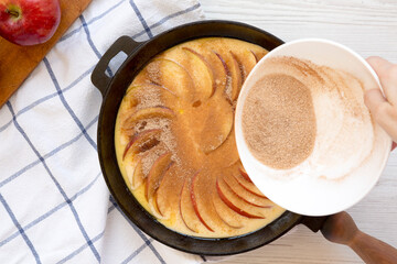Cooking Apple Dutch Pannekoek Pancake on a white wooden surface, top view. Overhead, from above, flat lay.