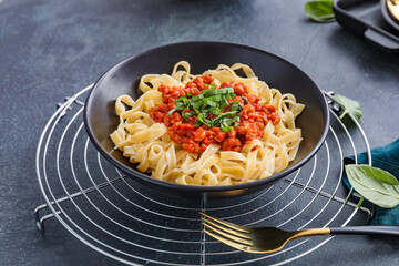 Plate with tasty pasta bolognese on dark background