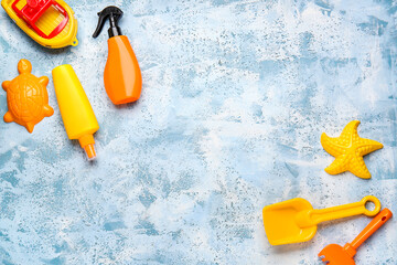 Sunscreen cream with beach sand toys on color background
