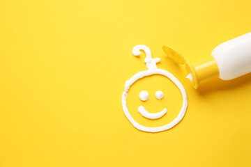 Drawing of baby made with sunscreen cream on color background