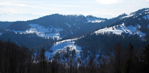 mountain landscape in the morning in full sun with snow on meadows. 