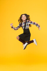 Time for fun. Active girl feel freedom. Fun and jump. Happy childrens day. Jump concept. Break into. Feel inner energy. Girl with long hair jumping on yellow background. Carefree kid summer holiday