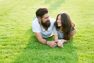 Fototapeta premium Happy summer. Happy family relax on green grass. Couple in love dating on natural landscape. Happy vacation. Family recreation. Enjoyment and relaxation. Being happy together