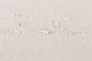 Light fabric texture with water drops. Abstract background. Selective focus.