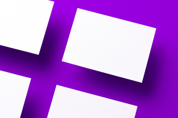 Obraz na płótnie Canvas Blank white businesscards on purple background, copy space